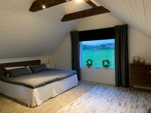1 dormitorio con cama y ventana grande en Lyckebo en Malmköping