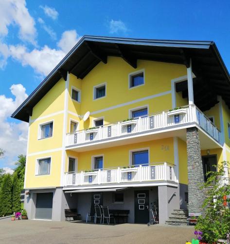 a yellow building with white balconies on it at Haus Staubmann Nähe Red Bull Ring Spielberg in Rattenberg