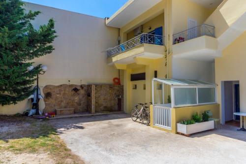 a yellow building with a balcony and bikes parked outside at Hotel Loukas Vrachos in Paralia Vrachou