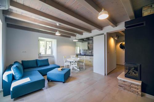 een woonkamer met een blauwe bank en een open haard bij Casa Salita Garibaldi in Opatija