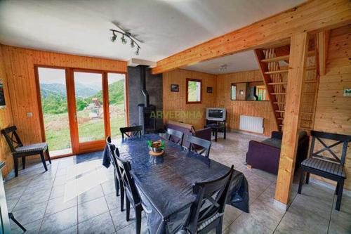 une salle à manger avec une table et un salon dans l'établissement Chalet Puy Ferrand, à Chambon-sur-Lac