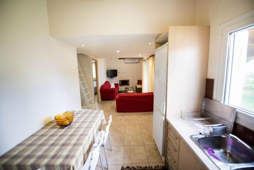 a kitchen with a table and a sink and a living room at Agios Andreas Beach Villas in Áyios Andréas Messinias