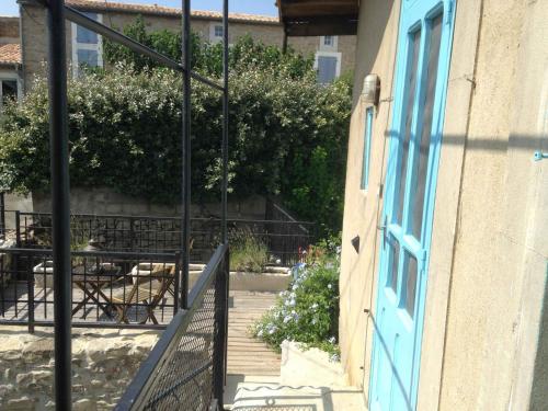 klatka schodowa z niebieskimi drzwiami, stołami i krzesłami w obiekcie Chambre du Charron w mieście Azillanet