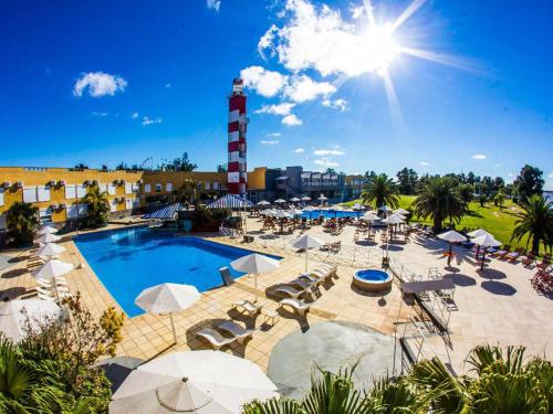 una piscina con sillas y sombrillas y un faro en Marina del Faro Resort en Termas de Río Hondo