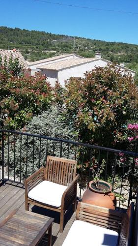 a balcony with two chairs and a table and a view at Chambre du Charron in Azillanet