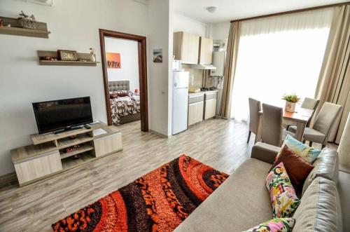 a living room with a couch and a television and a kitchen at Summerland Happy Blue Apartments in Mamaia
