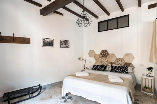 a bedroom with a bed in a room with white walls at ManillaHouse in Montepulciano