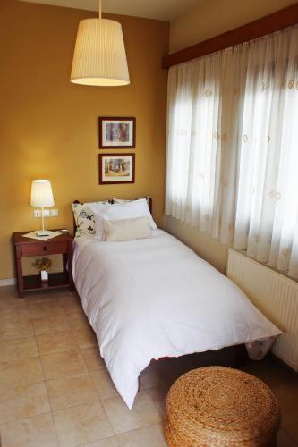 a bedroom with a white bed and a window at Agape in Kala Nera
