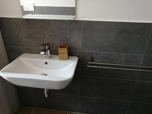 a white sink in a bathroom with a tile wall at Appartamento fronte mare in Porto Recanati