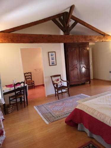 une chambre avec un lit, une table et des chaises dans l'établissement Coté Marais - gite familial, à Chaillé-les-Marais