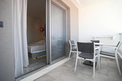 a room with a table and chairs and a bedroom at Athinais Luxury Apartments in Hanioti