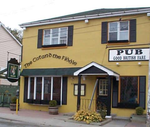 a yellow building with a pug and grandchildren the table at The King George Inn in Cobourg