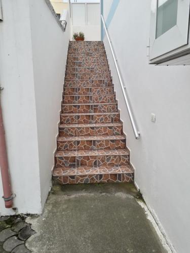 a stairway with a red brick staircase next to a building at Rooms and Apartments Analipsi in Shëngjin