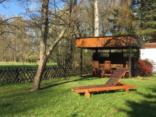 a picnic shelter with a bench and a table and chairs at CS-Ranchhaus in Hörselberg-Hainich