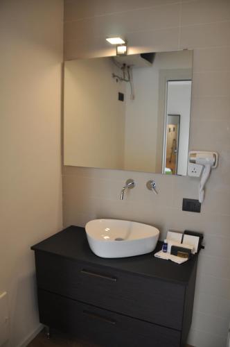 a bathroom with a sink and a mirror on a counter at EVA LUXURY ROOMS CAGLIARI in Cagliari