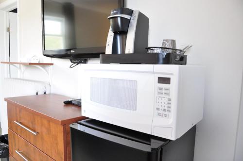 a microwave sitting on top of a kitchen counter at Moonlight Inn and Suites Sudbury in Sudbury