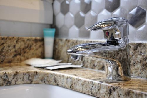 a bathroom sink with a chrome faucet at Moonlight Inn and Suites Sudbury in Sudbury