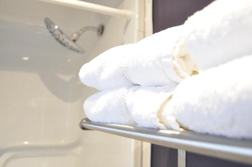a stack of white towels on a rack at Moonlight Inn and Suites Sudbury in Sudbury