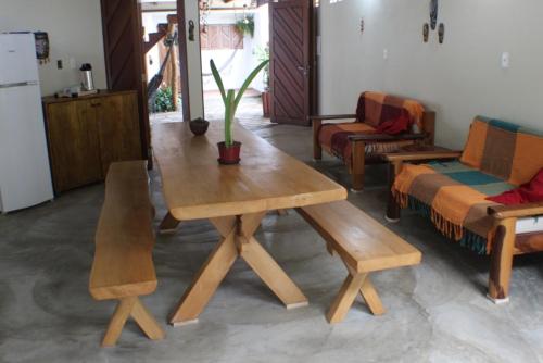 a wooden table and chairs in a living room at Pousada Rio Sagi in Baía Formosa