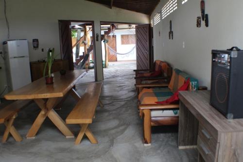 a living room with wooden tables and a tv at Pousada Rio Sagi in Baía Formosa