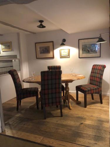 a dining room with a wooden table and chairs at The George at Nunney in Frome