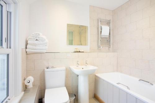 a bathroom with a sink and a toilet and a bath tub at Hotel Continental in Whitstable