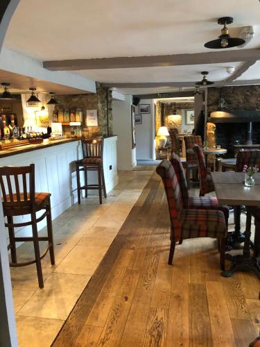 a restaurant with chairs and a table and a bar at The George at Nunney in Frome