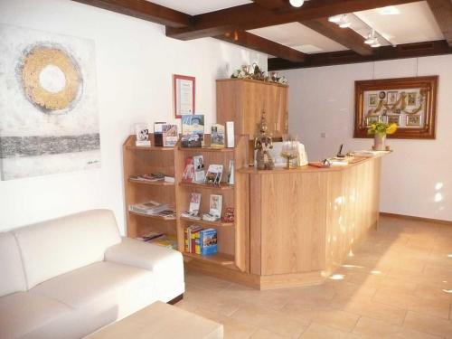 a living room with a couch and a book shelf at Landgasthaus Bonn in Baunatal