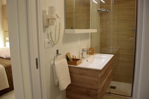 a bathroom with a sink and a shower with a mirror at Le Suite del Duomo in Cava deʼ Tirreni