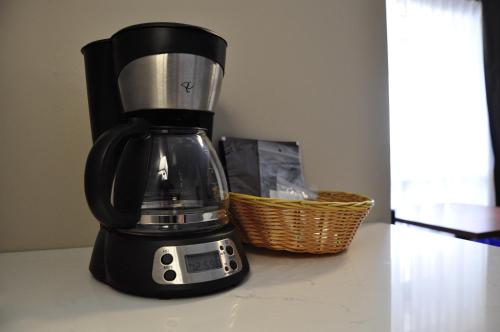 a black blender sitting on a counter with a basket at Moonlight Inn and Suites Sudbury in Sudbury