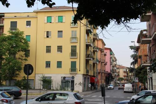 a yellow building on a city street with cars parked at ARCOBALENO AFFITTACAMERE in Verona