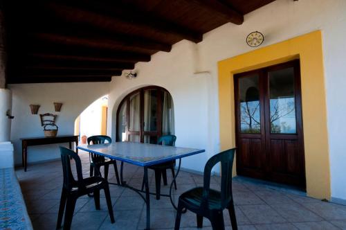 ein Esszimmer mit einem Tisch, Stühlen und einer Tür in der Unterkunft Casa Vacanze Dell'Avvocato in Malfa