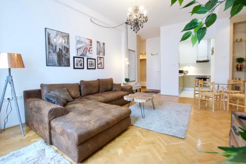 a living room with a brown couch and a table at Standard Apartment by Hi5 - Madách Imre 1 in Budapest