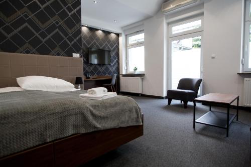 a bedroom with a bed and a desk and a chair at N°50 in Poznań