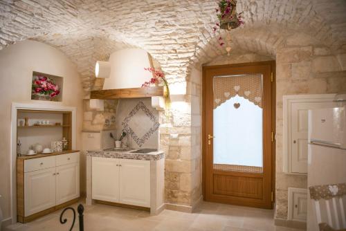 a kitchen with a door and a stone wall at La pietra Maga in Martina Franca