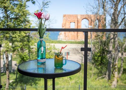 a vase with a flower and a drink on a table at Apartamenty Klifowa z widokiem na morze in Trzęsacz