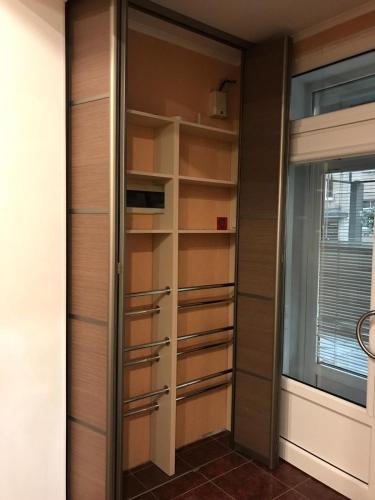 a walk in closet with wooden doors and shelves at DAUGAVPILS in Daugavpils