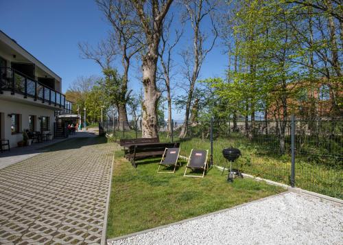 two chairs and a picnic table in a park at Apartamenty Klifowa z widokiem na morze in Trzęsacz