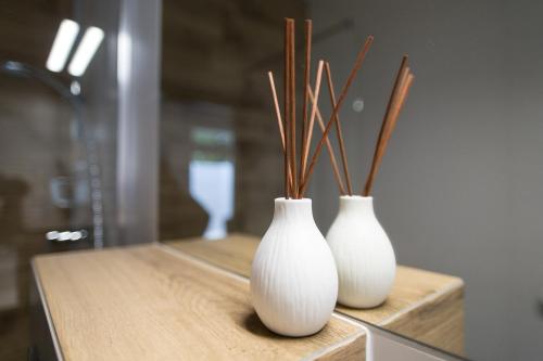 three white vases with sticks in them on a counter at N°50 in Poznań