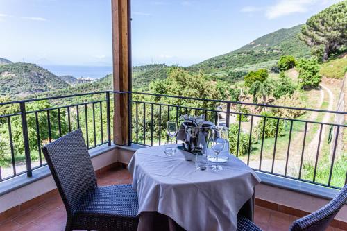 a table with wine glasses on top of a balcony at Villa Ginevra Resort Agrituristico in Ficarra