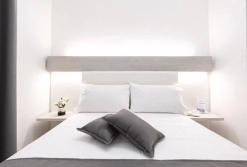a white bed with a gray pillow on it at Imera B&B in Favignana