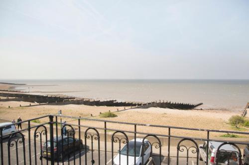 een uitzicht op een strand met auto's op het zand bij Hotel Continental in Whitstable