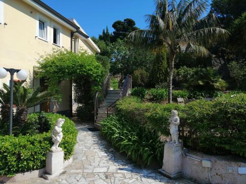 聖多米尼卡的住宿－L'Eden B&B，房屋前方设有雕像的花园
