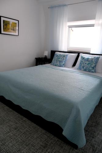 a bedroom with a large bed with blue pillows at Main Square Oval Apartment in Zagreb