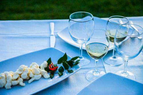 a table with two glasses of wine and a plate of food at Giardini Malaspina in Bosa