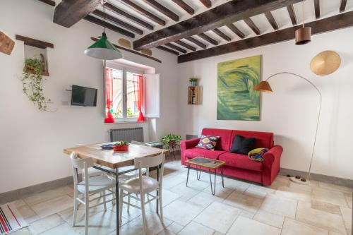 a living room with a red couch and a table at ManillaHouse in Montepulciano