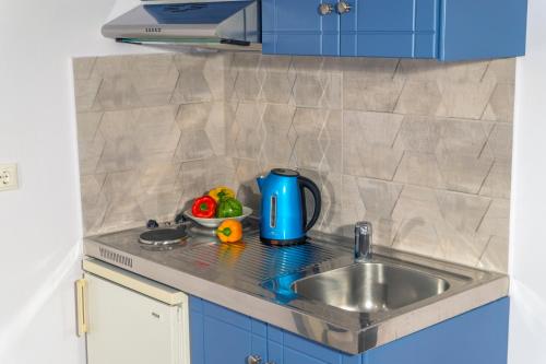a kitchen with a sink and a blue appliance at Hotel Loukas Vrachos in Paralia Vrachou