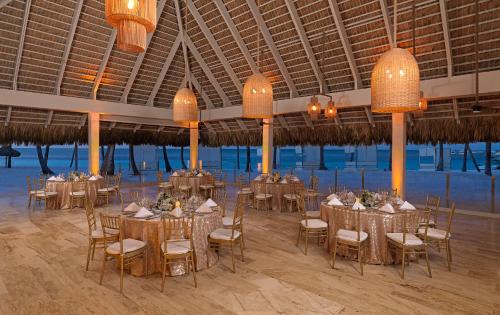 a banquet hall with tables and chairs and chandeliers at Meliá Punta Cana Beach Wellness Inclusive - Adults only in Punta Cana