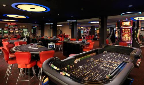 a casino with red chairs and tables and machines at Meliá Punta Cana Beach Wellness Inclusive - Adults only in Punta Cana