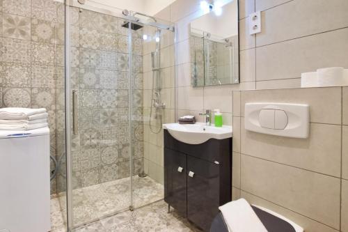 uma casa de banho com um chuveiro, um lavatório e um WC. em Standard Apartment by Hi5 - Rákóczi út 23 em Budapeste